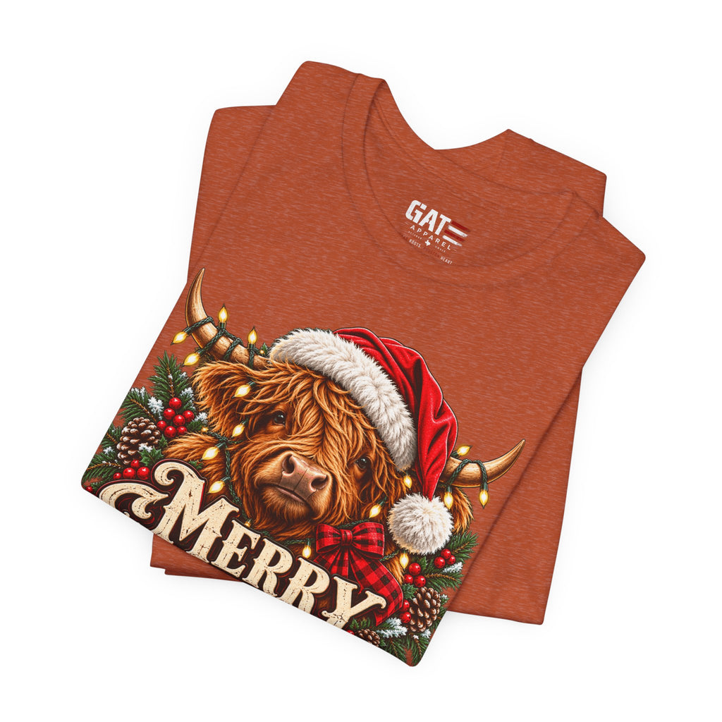 Folded burnt orange Highland cow Santa hat Merry Christmas graphic T-shirt, print close-up