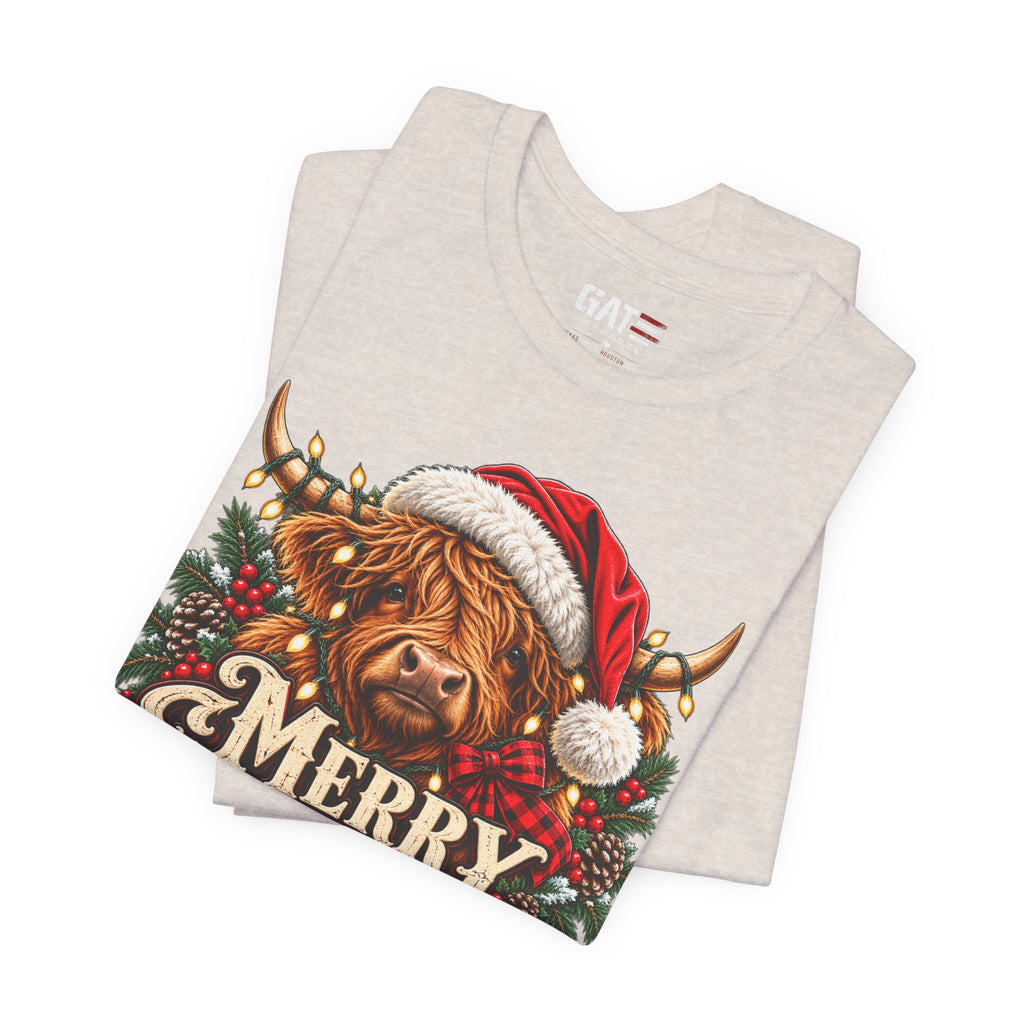 Folded light beige Highland cow Santa hat Merry Christmas graphic T-shirt, print close-up