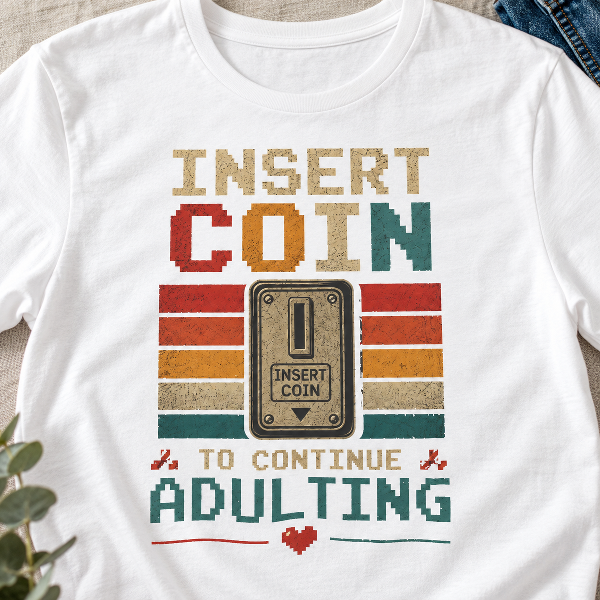 Insert Coin to Continue Adulting Shirt | Retro Gamer Tee — close-up lifestyle flat lay