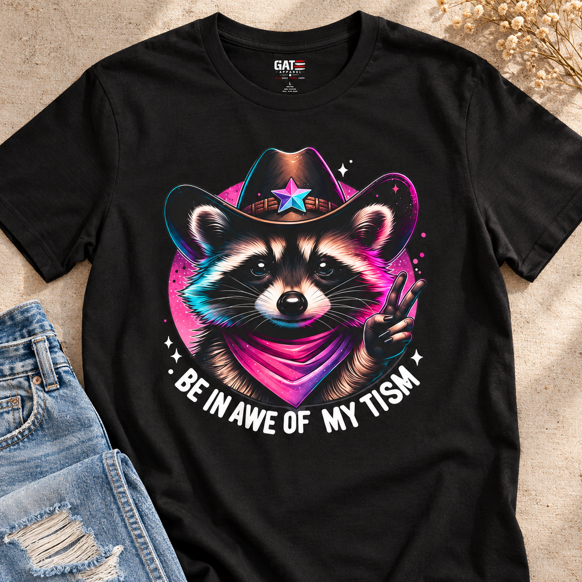 Be in Awe of My Tism Shirt | Raccoon Cowboy Graphic Tee — close-up lifestyle flat lay