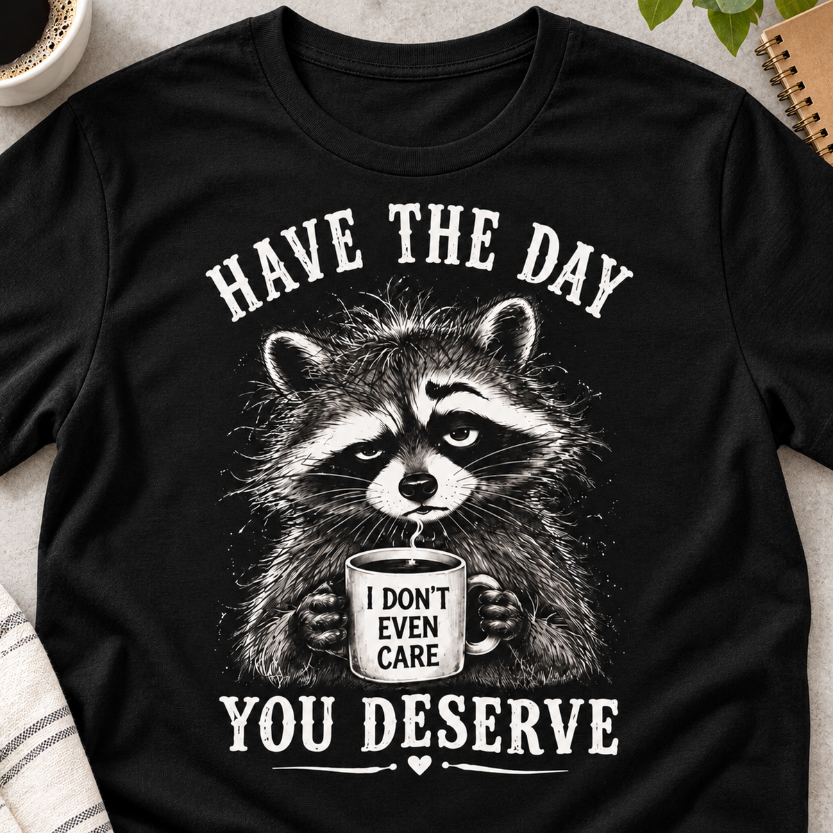 Have the Day You Deserve Raccoon Shirt | Funny Tee — close-up lifestyle flat lay